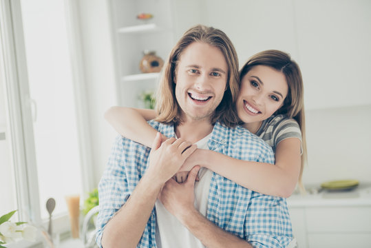Portrait of romantic attractive couple hugging looking at camera enjoying time at home together looking at camera. Trust support understanding concept