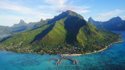 Aerial view of tropical paradise of Moorea island, turquoise crystal clear water of scenic blue lagoon, over water bungalows on foot of Mount Rotui - South Pacific Ocean, French Polynesia landscape