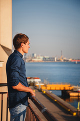 Close up of young stylish guy, man at pier enjoying freedom, happy outdoor portrait