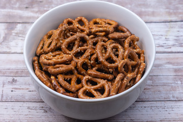 Bowl of pretzels isolated on wood table background
