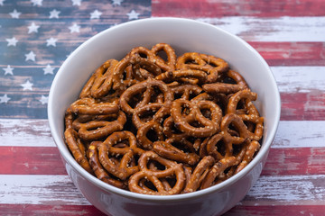 Pretzels in white bowl on USA flag background for summer party