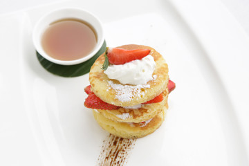 Pancakes with fresh strawberries and maple syrup