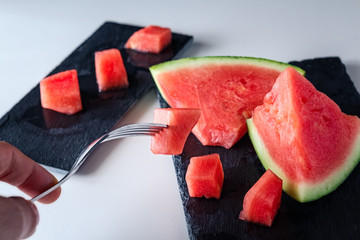 Closeup of a composition of fresh fruit of the summer, watermelon on white background with slate....