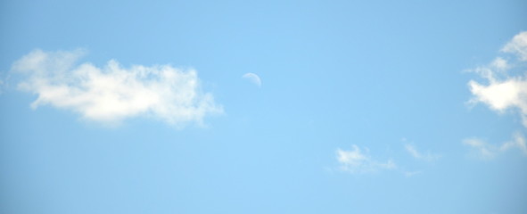 Blue sky background with clouds and moon