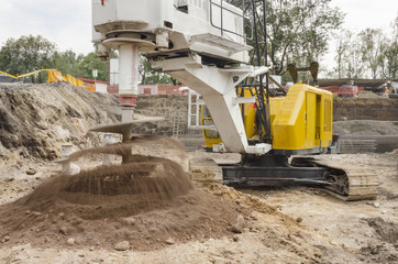 Construction drilling machine with dirt auger