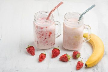 Banana and strawberry yogurt with strawberries and bananas on a light background