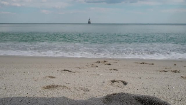Bare women's feet walking towards the sea