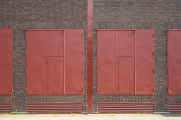 Red painted vintage industrial steel door and brick exterior door of warehouse. Big red steel door...