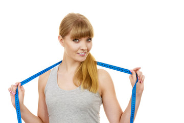 Fitness girl holds measure tape, measuring her body