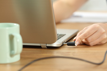 Woman plugging charger in a laptop