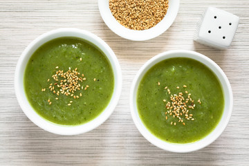 Hausgemachte Zucchinicremesuppe mit Sesam, fotografiert mit natürlichem Licht (Selektiver Fokus, Fokus auf die Suppen)