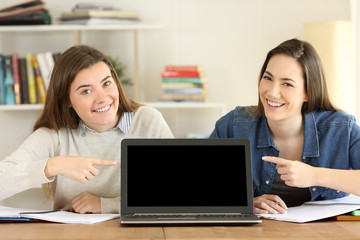 Two students pointing at laptop screen mockup