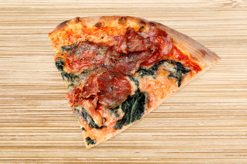 Stück Pizzza Spinat Salami auf Holztisch Brettchen