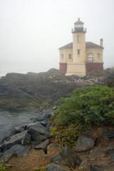 Fototapeta na wymiar Heavy fog surrounds the Coquille River Lighthouse and the surrounding landscape near Bandon, Oregon