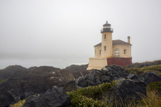 Heavy fog surrounds the Coquille River Lighthouse and the surrounding landscape near Bandon, Oregon