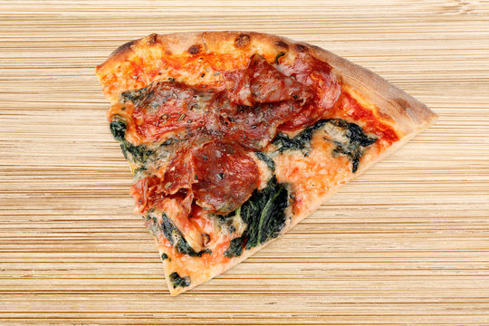 St&uuml;ck Pizzza Spinat Salami auf Holztisch Brettchen