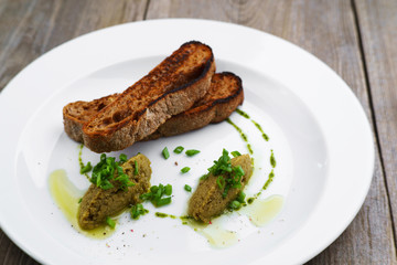 Gourmet snack, traditional Italian cuisine, restaurant menu, food photo concept. Chef's olive tapenade and rye baguette in restaurant serving