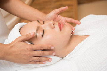 Obraz na płótnie Canvas Face massage. Spa skin and body care. Close-up of young woman getting spa massage treatment at beauty spa salon. Facial beauty treatment.