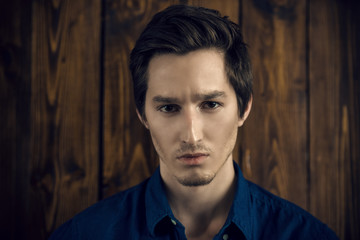 boy by wooden wall