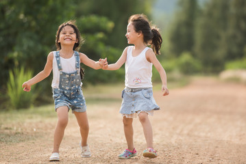 Ratchaburi, Thailand - June 18, 2017: two girl relaxxing on the road in country side © nareekarn