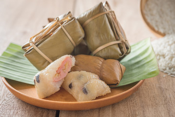 khao tom mat - thai dessert - sticky rice, banana and black beans wrapped in banana leaf hand make