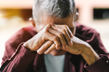 senior man covering his face with his hands.vintage tone