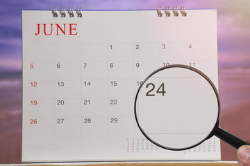 Magnifying glass in hand on calendar you can look Twenty-four day of month,Focus number Twenty-four...
