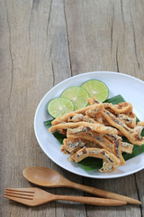 fried squid of Thai seafoods in the white dish on wood floor.