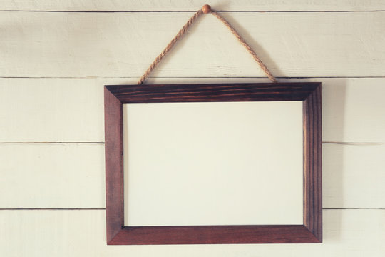 Vintage wooden frame of blank to hang on a wooden wall.