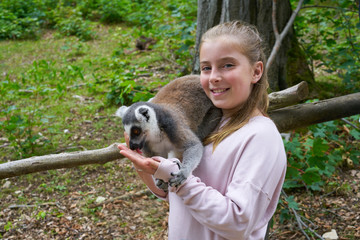 Kid girl having fun with ring tailed lemur animal © lunamarina