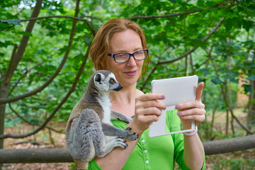 woman taking photo selfie with ring tailed lemur © lunamarina