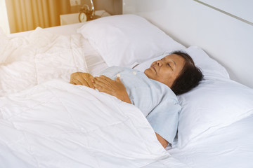 old woman sleeping on a bed