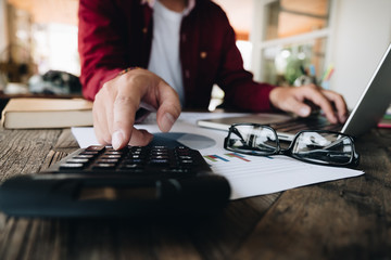 Fototapeta premium Close up view of bookkeeper or financial inspector hands making report, calculating or checking balance. Home finances, investment, economy, saving money or insurance concept