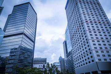 Obraz na płótnie Canvas Bottom view of modern skyscrapers in business district against blue sky