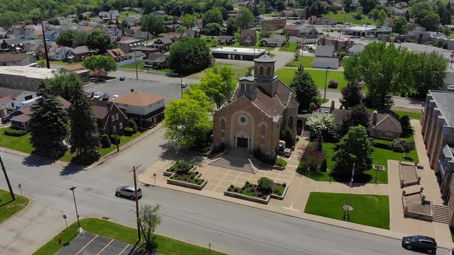 A slow forward moving aerial establishing shot of a church in the residential district of a small town. Pittsburgh suburbs.  	