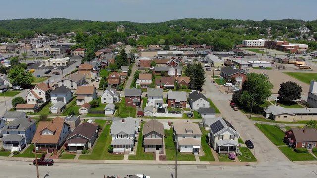 A slowly lowering aerial establishing shot of a small town's residential district. Pittsburgh suburbs.  	