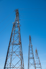 three giant electric towers under the blue sky