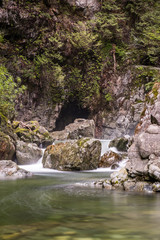 Fototapeta na wymiar water rushing down the rocky creek inside forest