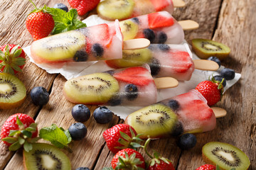 Healthy Whole Fruit Popsicles with strawberries, kiwi and blueberries on a stick close-up. horizontal