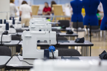 nterior of garment factory shop. Closes making atelier with several sewing machines. Tailoring...