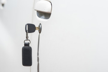 The car keys were plugged into the white car door