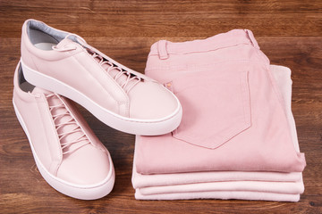 Pair of womanly leather shoes, pants and clothing on rustic boards