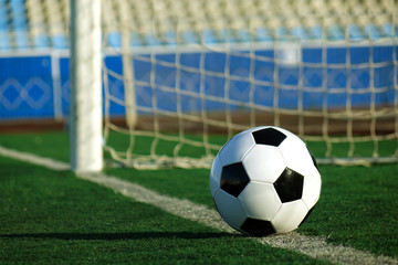 Football on a green field. The ball in the goal.