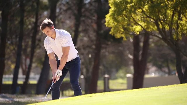 A young male golfer is disappointed with his golf swing on a course in the summer