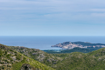 Mallorca, Aerial view on holiday island coast and village at sea with lighthouse from mountains