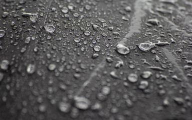 Water rain drops on black umbrella surface.Soft focus