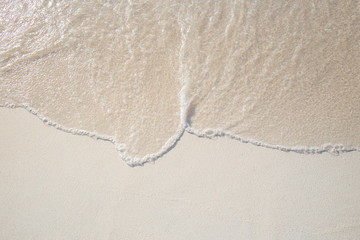 The movement of the waves on the sand is smooth and fine for  background,