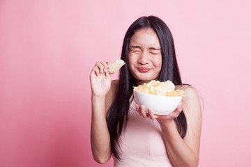 Young Asian woman eat potato chips.