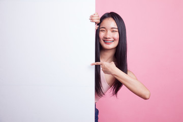 Young Asian woman point to a  blank sign.