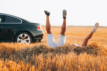Happy traveling couple.Sunny summer colors.Romantic mood.Happy mood.Young Couple Standing Next To Sport Car.Young couple in love 